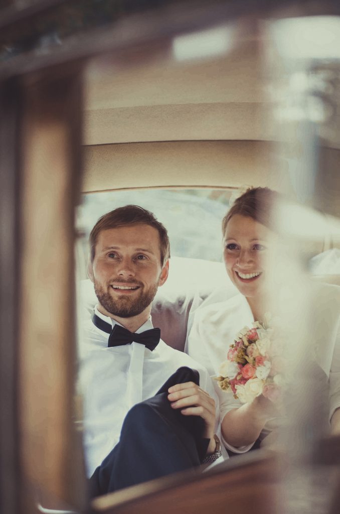 Ein Brautpaar sitzt im Auto
