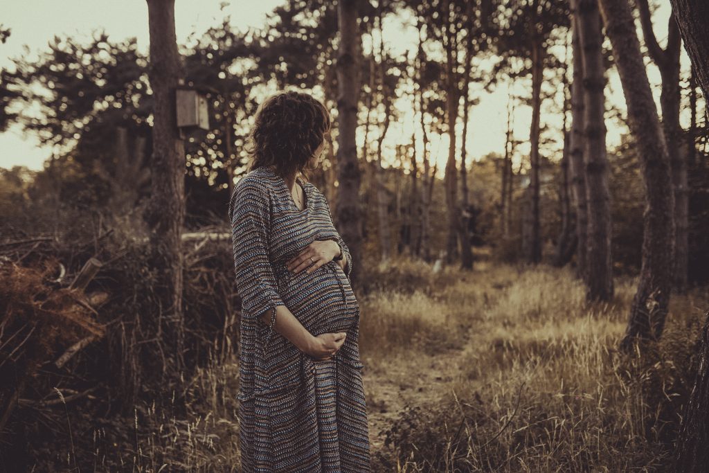 Eine schwangerere Frau hält sich den Bauch