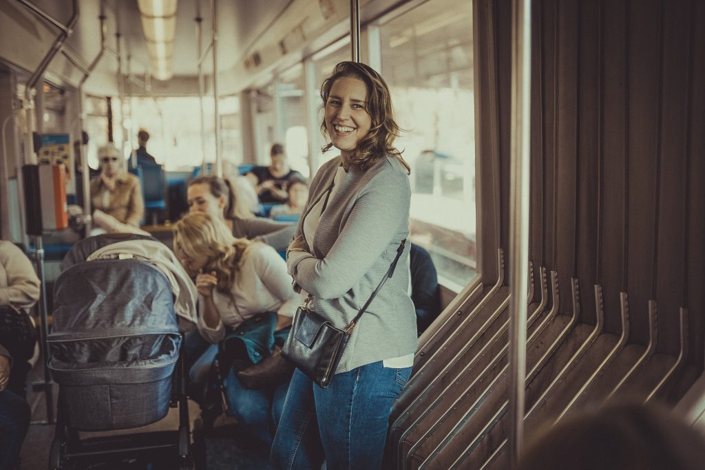 Frau lacht und steht in der Straßenbahn