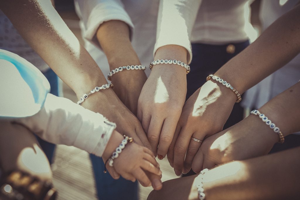 Frauen halten die Hände zusammen und feiern den Junggesellenabschied