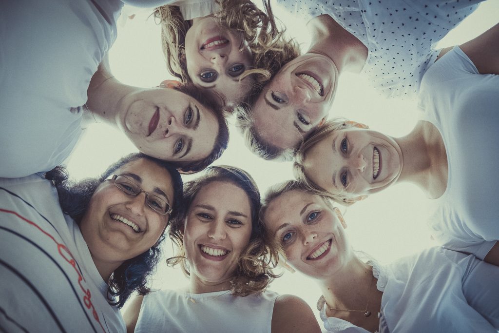 frauen stehen im Kreis und lachen