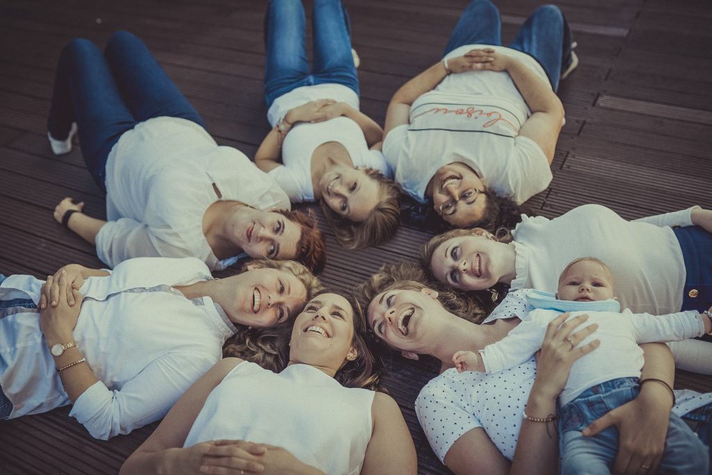 Frauen liegen im Kreis und lachen