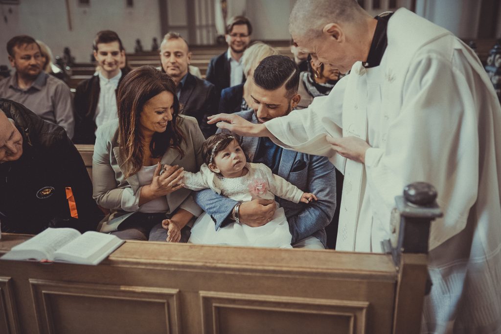 Priester oder Pfarrer segnet das Kind