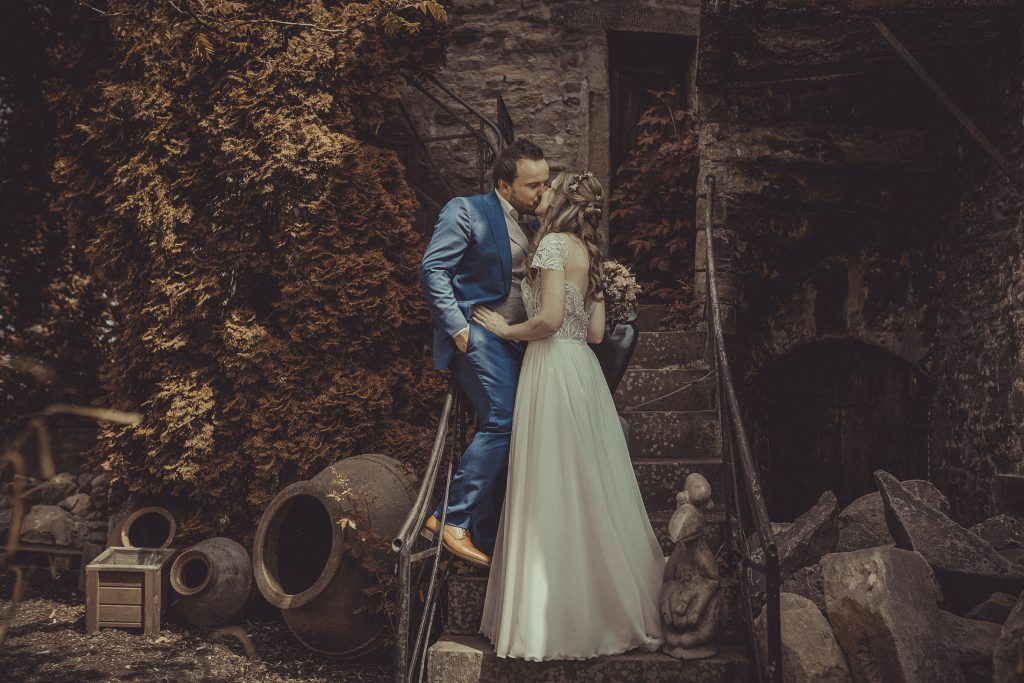 Brautpaar küsst sich auf einer Treppe